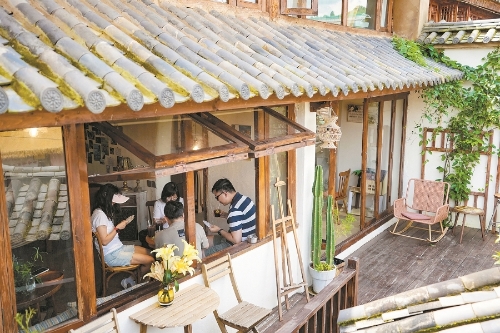 游客在乐居村一家咖啡店内打牌休闲。 新华社