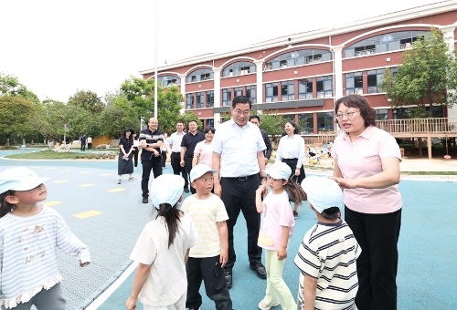在昆明市教工第一幼儿园白龙潭园区，杨承新与孩子们亲切互动。_副本