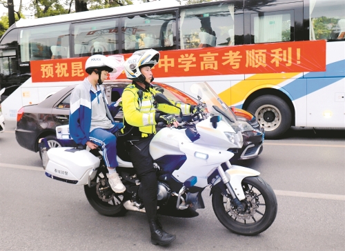 6月7日，在昆明市第五中学考场外，骑警护送跑错考场的考生前往考场。 新华社